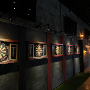 Rows of dart boards line the wall at BowGames Dallas, inviting friendly competition and good times in this lively bar.